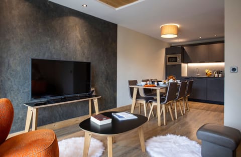 Inviting entertainment space featuring plush seating and a flat-screen TV, designed for cozy evenings in.