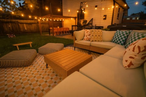 Gather for conversations on the sectional beneath string lights.