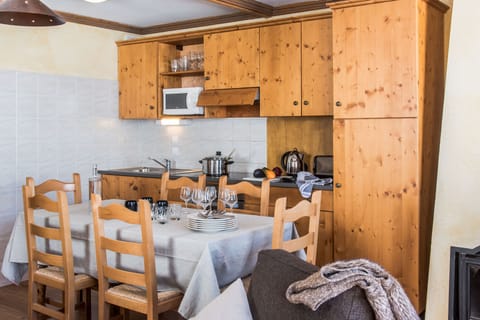 Fully equipped kitchenette with wooden cabinetry and cozy dining table.