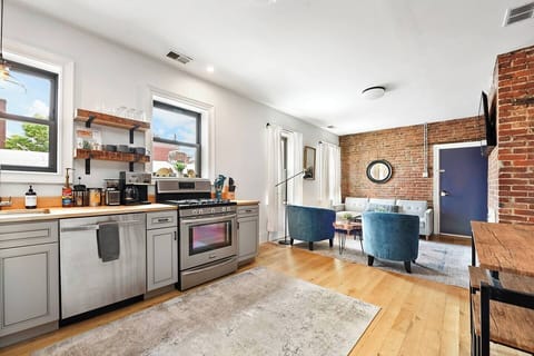 Enjoy natural light from two huge windows in this fully equipped kitchen, complete with all the essentials and a cozy rug for added charm. Perfect for home cooks and food lovers!