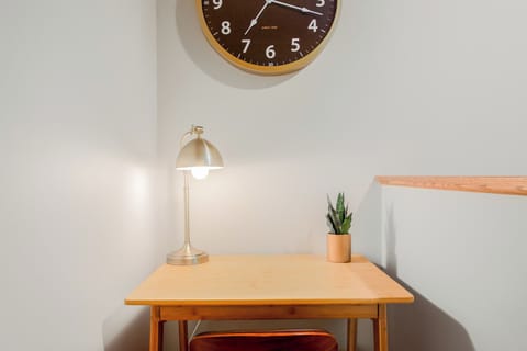 Dedicated workspace with a desk, chair, lamp, and clock