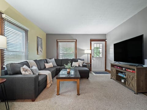 Cozy living room with large sectional sofa, smart TV & board games for family fun 🎲🛋️✨