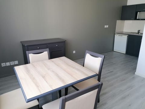 A spacious nook adorned with a modern dining table and rustic sideboard sets the stage for casual meals, blending comfort with functionality.