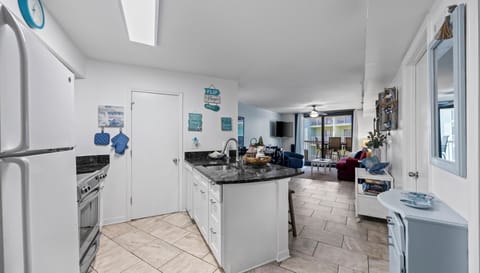 Fully equipped kitchen with modern appliances and breakfast bar seating.