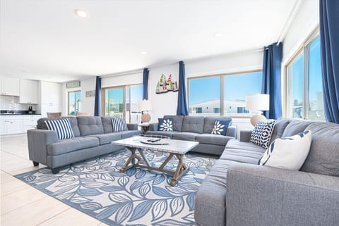 The main living area includes a sofa set, cable TV, and sliding glass doors that open up to the front balcony.
                