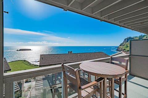 Relax on your private balcony with ocean vistas subtly framed by nearby trees and buildings.