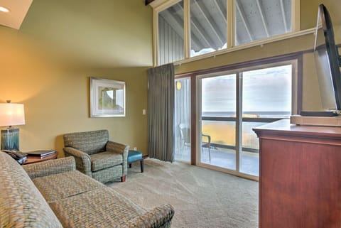 The inviting sitting area features plush chairs and a pullout couch, leading to a private ocean-view balcony that enhances the serene atmosphere.