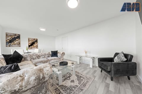 Stylish lounge with plush velvet sofas, Smart TV, and plenty of natural light—perfect for relaxing in comfort.