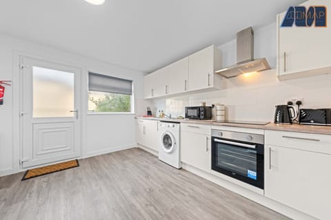 Spacious and fully equipped kitchen with modern appliances, including oven, hob, microwave, washing machine, kettle, and toaster. Ideal for long stays and home-cooked meals, with plenty of storage and natural light.
