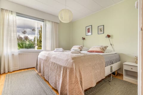 This cozy and sunlit bedroom features two comfortable single beds set together, soft linens, and a calming view of the garden. Ideal for a restful night’s sleep after a day of exploring Rovaniemi.