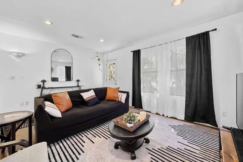 At the center of the room, a plush sectional sofa in a deep charcoal gray offers a luxurious place to unwind.