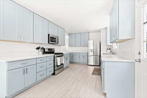 Spacious kitchen featuring light blue cabinets, stainless steel appplicances