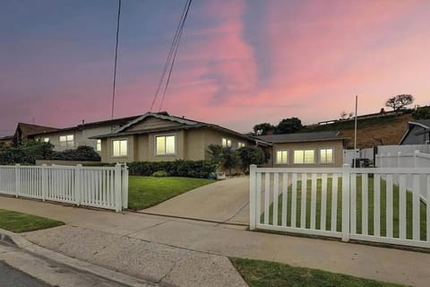 cozy single-story home with a spacious lawn, large windows, & large driveway