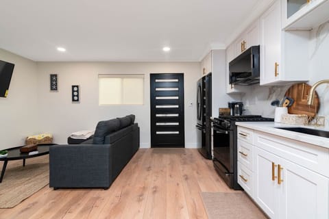 View of the front door, kitchen and pull out couch from the dining table. 