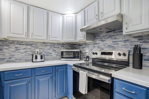 Bright kitchen with sleek cabinetry, double sink, and stainless steel appliances, fully stocked for easy at-home cooking.