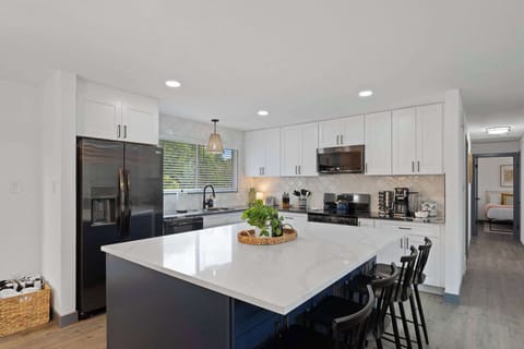 The remodeled kitchen has a large island with seating in the middle. 