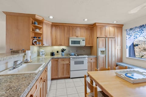 Fully stocked kitchen with white appliances.