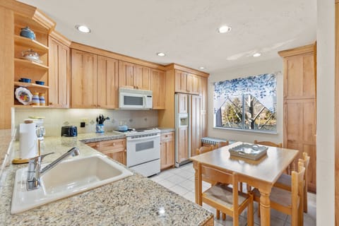Dining room table with seating for 6 people with daybed underneath window.