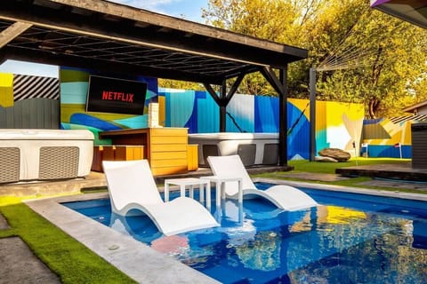 The sparkling blue pool invites you to relax, with loungers that seem to float just above the water’s surface