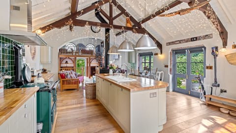 Light and bright there is a central island with a sink, perfect for prepping vegetables for dinner, an oven and hob, microwave and a feature AGA which is available during the winter months.