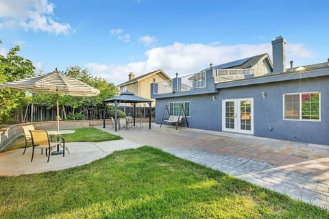 Backyard with patio, gazebo, dining, swing, and lawn for relaxing or entertaining.