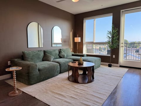 Spacious living room featuring a cozy L-shaped sofa, a full-size air mattress, and a 65" Smart TV with preloaded access to Netflix, Hulu, and Disney+, all set up for your enjoyment.