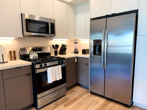 Experience extended comfort with a fully equipped kitchen featuring a coffee machine, stovetop, and microwave—everything you need for a seamless long-term stay.