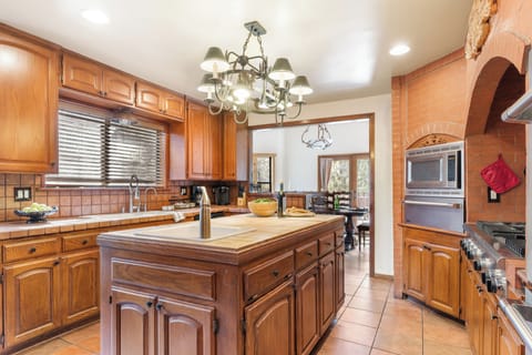 A chef's dream. This spacious kitchen features a unique brick oven archway, a large island, and plenty of counter space to prepare your favorite meals.