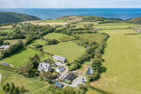 Aerial view of the cottage with views over fields towards the sea