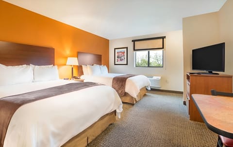 Unwind in bright double-queen comfort with TV and workspace.