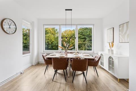 Ein großzügiger, lichtdurchfluteter Essbereich mit stilvoller Einrichtung und Ausblick ins Grüne bietet den perfekten Ort für gemeinsame Mahlzeiten.