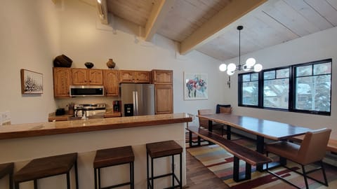 Bar stool seating along side banquet live edge dining table seats many. 