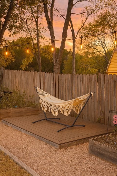 spacious back yard connects to the kitchen: hammock, covered patio with chairs, fire place.