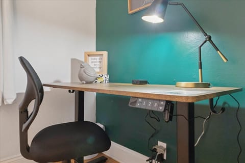 Power up your productivity in our South Bend guest retreat—featuring an electric standing desk with built-in outlets, charging ports, and a comfy chair. Perfect for remote work near Notre Dame