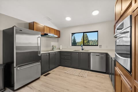 Bright, open kitchen with stainless steel appliances and a window framing stunning waterviews