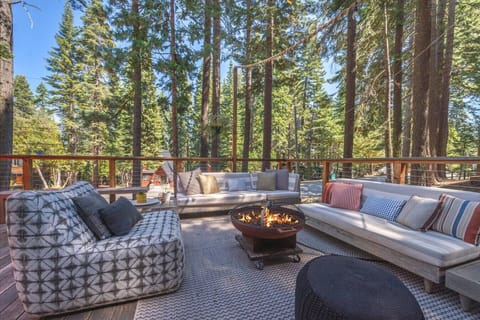 Beautiful outdoor living area on the front deck equipped with a gas grill, gas fire pit, lounge furniture and a large dining table.
