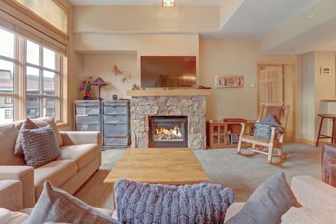 Cozy living area in Passage Point at Copper Mountain, Colorado. Features a stone-framed gas fireplace, warm mountain décor, and comfortable seating—perfect for après-ski relaxation.