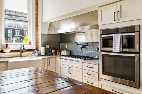 Kitchen | Bright chef’s kitchen with granite counters, gas range, double ovens, and large island