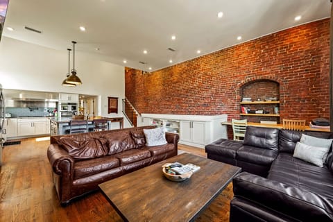 Living Room| Bright open-concept space with leather seating, cozy fireplace, and smart TV