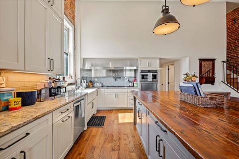 Kitchen | Bright chef’s kitchen with granite counters, gas range, double ovens, and large island