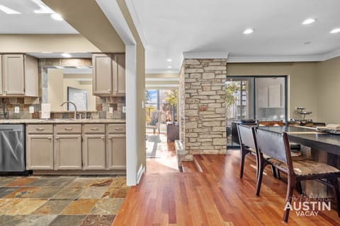 Kitchen and dining flow together, with stone accents and sunlight to spare.