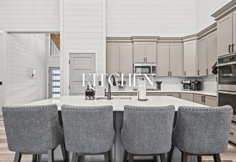 The kitchen’s sleek design and generous island make cooking for a crowd both easy and enjoyable.
