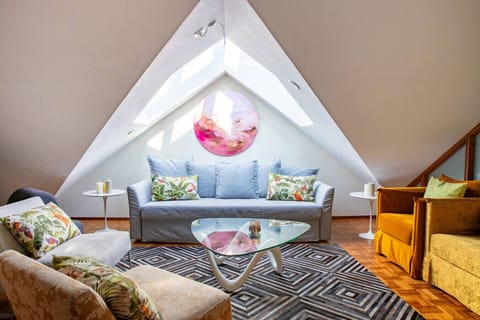 A bright, inviting seating area under the skylights, with comfortable sofas and vibrant cushions — perfect for relaxing or spending time together.