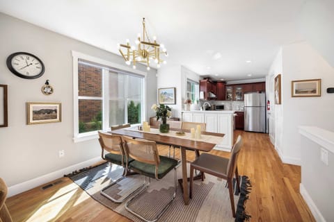 Dining Area – Share meals under a statement chandelier, with natural light streaming through large windows.