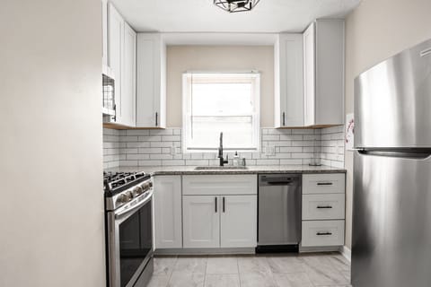 Modern kitchen with stainless steel appliances, subway tile backsplash and all of the necessities for your stay!