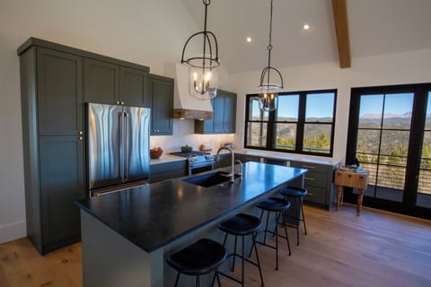 The kitchen features island seating and large basin sink with instant hot water