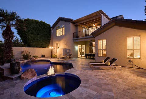 Backyard oasis featuring a covered patio w/ dining, sparkling pool with spa, plus a built-in grill and fireplace perfect for outdoor gatherings.