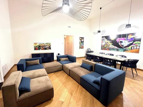 Vista del salone con in primo piano il divano modulare e tavolo da pranzo sullo sfondo.