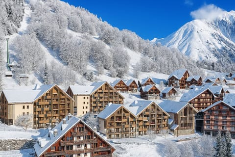 Charming alpine village blanketed in snow, surrounded by majestic mountain peaks in Vaujany.