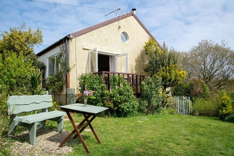 front of the property with a wooden bench and table on the grass.